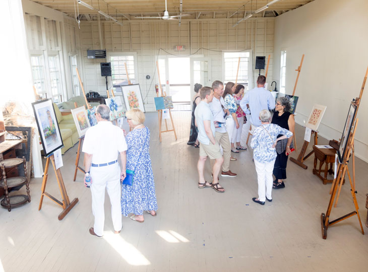 People looking at artwork displayed on easels